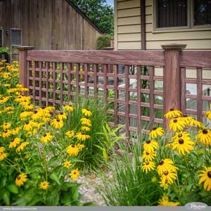 Looking for an enclosure to hide your air conditioner or trash cans? How about a PVC vinyl wood grain lattice fence from Illusions Vinyl Fence? Shown here is the beautiful VSQL48 Old English Lattice panels in Grand Illusions Vinyl WoodBond Walnut. #landscapingideas #homeideas #fenceideas #backyardideas #homedecor